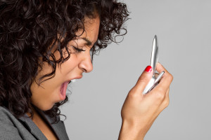 Frustrated black woman yelling into mobile phone